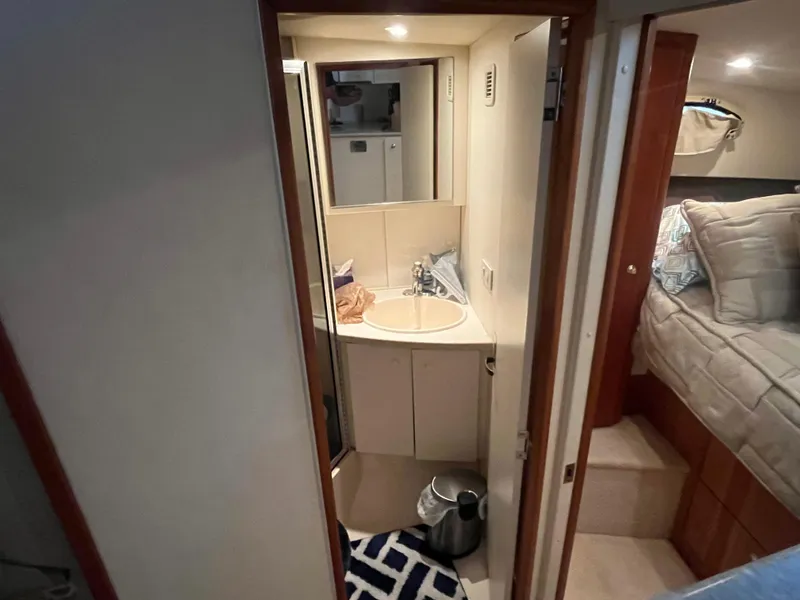 Slide: The Image of 1999 Silverton 392 Aft Cabin bathroom with sink, mirror, and adjacent bedroom. - 33