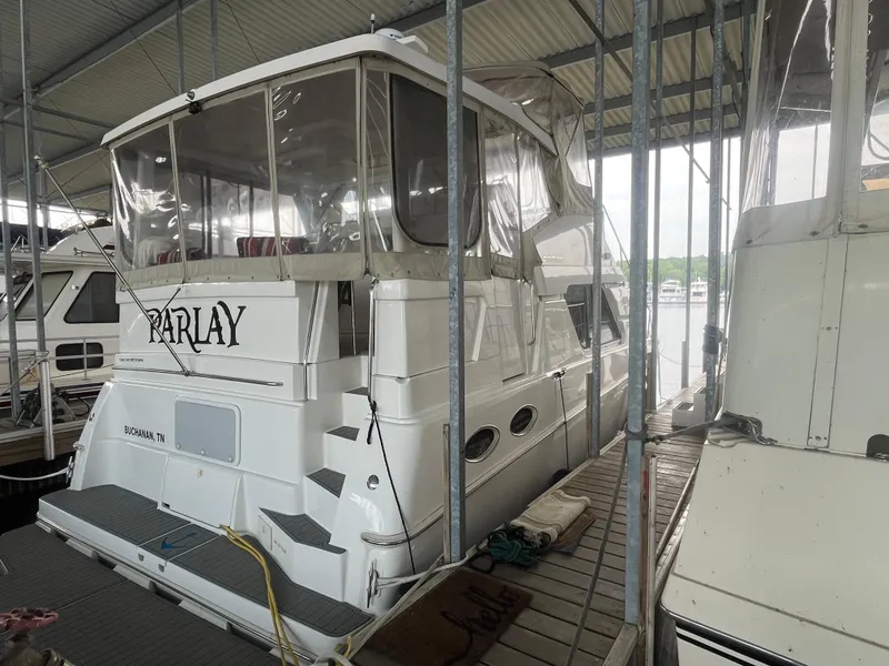 Slide: The Image of 1999 Silverton 392 Aft Cabin yacht docked in marina, covered and well-maintained. - 6