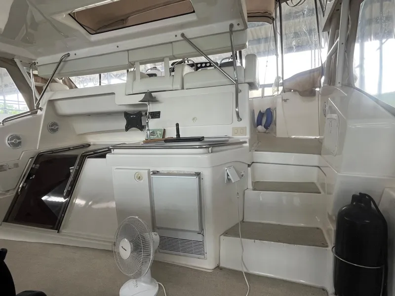 Slide: The Image of 1999 Silverton 392 Aft Cabin interior with stairs, fan, and seating area. - 7