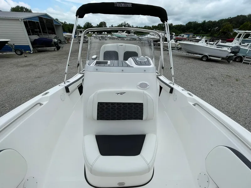 Slide: The Image of 2024 Tidewater 198 CC Adventure boat, white interior, parked in a marina with other boats. - 12