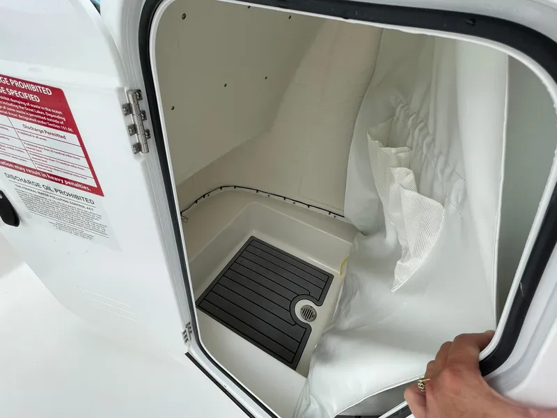Slide: The Image of 2024 Tidewater 198 CC Adventure boat interior storage compartment with drainage and curtain. - 15