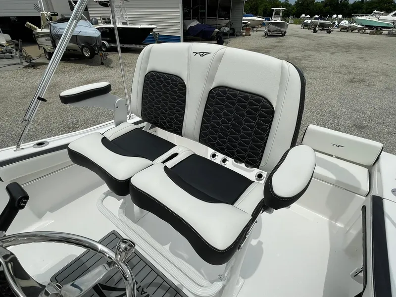Slide: The Image of 2024 Tidewater 198 CC Adventure boat seats, featuring black and white upholstery with armrests. - 24