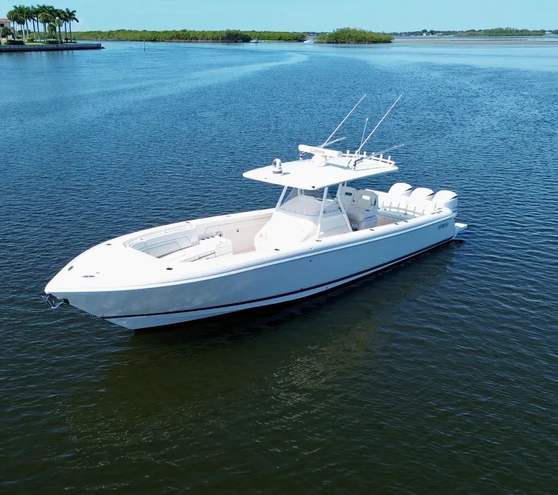 Slide: The Image of 2017 Intrepid 375 FE boat on calm water, clear sky, and lush shoreline. - 28