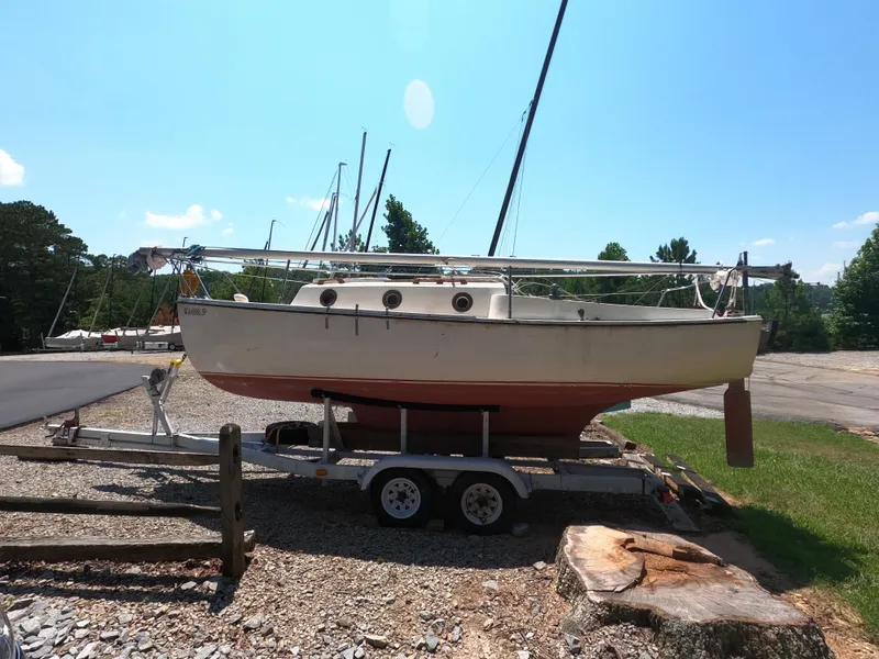 Slide: The Image of 1980 Com-Pac 23 sailboat on trailer, parked outdoors under clear blue sky. - 2