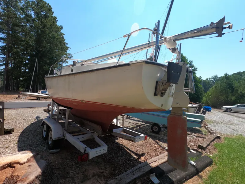 Slide: The Image of 1980 Com-Pac 23 sailboat on trailer, parked outdoors near trees. - 6