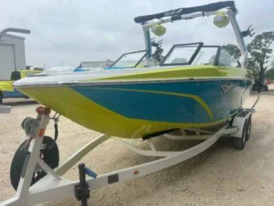 Slide: The Image of 2024 Tigé Z3 boat in vibrant blue and green on a trailer, ready for adventure. - 5