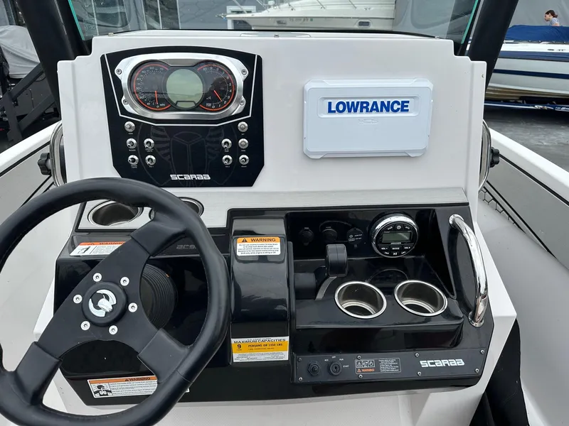 Slide: The Image of Dashboard of 2018 Scarab 195 Open ID boat with steering wheel and controls. - 2