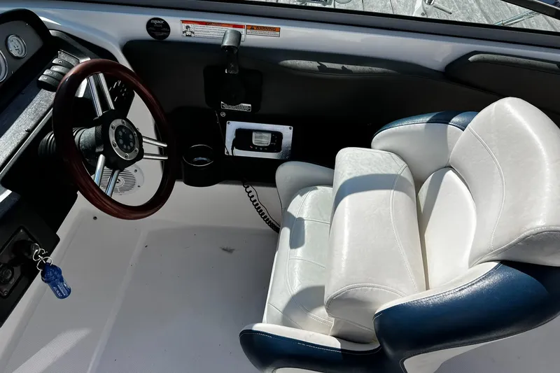 Slide: The Image of 2008 Regal 2200 Bowrider cockpit with white and blue seating, steering wheel, and controls. - 10