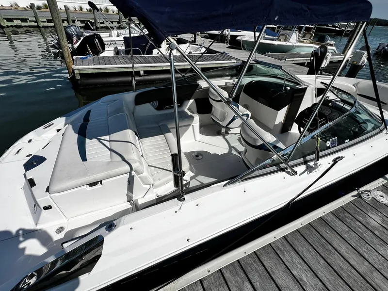 Slide: The Image of 2008 Regal 2200 Bowrider boat docked, featuring spacious seating and sleek design. - 5