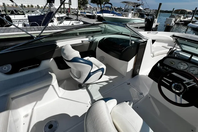 Slide: The Image of 2008 Regal 2200 Bowrider interior with steering wheel and seating at marina. - 7