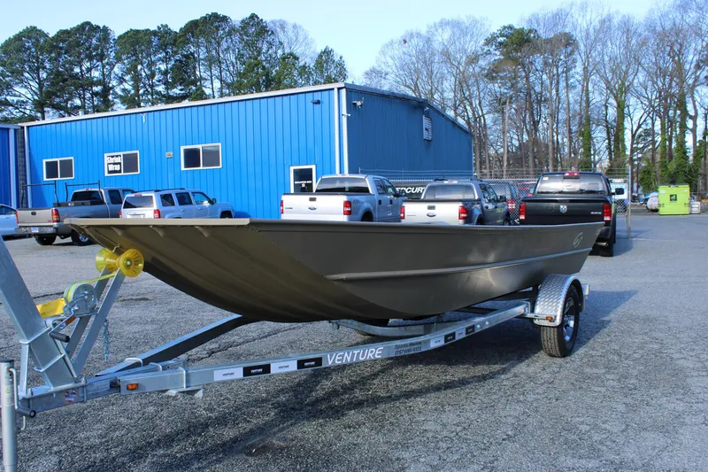 Slide: The Image of 2025 G3 Gator Tough 1860 VBW boat on trailer in parking lot. - 2