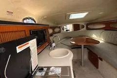 Slide: The Image of 2003 Sea Ray 260 Sundancer cabin interior with kitchenette and seating area. - 3