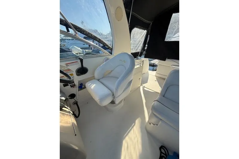 Slide: The Image of 2003 Sea Ray 260 Sundancer cockpit with white captain's chair and steering controls. - 5