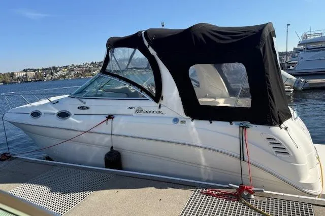 Slide: The Image of 2003 Sea Ray 260 Sundancer boat docked at marina with black canopy. - 7