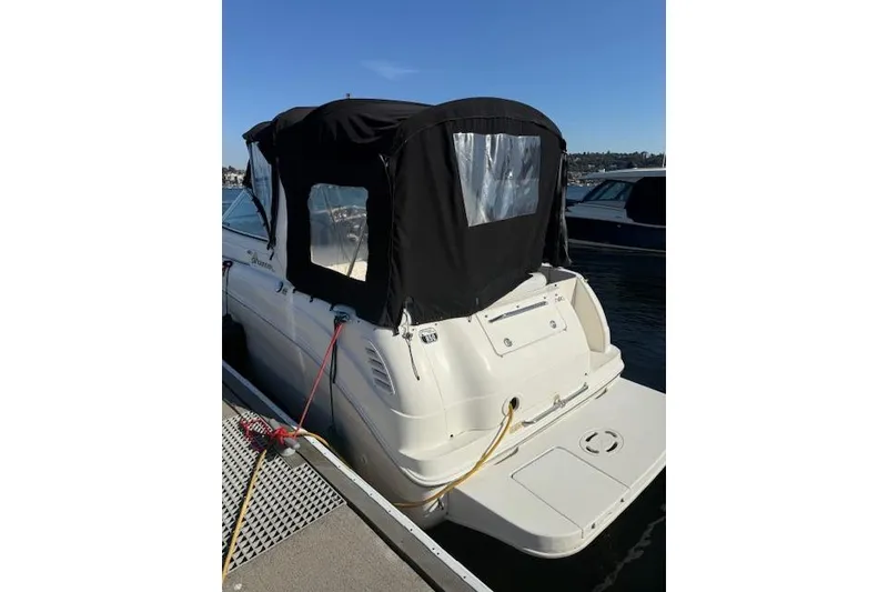 Slide: The Image of 2003 Sea Ray 260 Sundancer docked with black canopy, rear view. - 8
