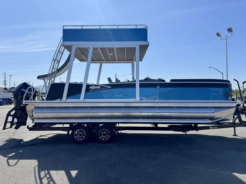 Slide: The Image of 2025 Avalon 2585 27 Catalina CRFS pontoon boat on trailer, side view, blue and silver design. - 7