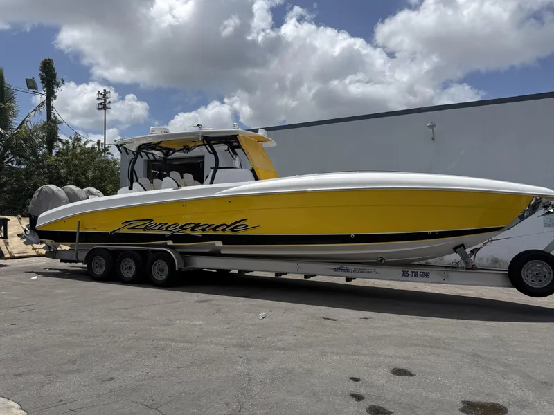 Slide: The Image of 2023 Renegade 38' Open boat in vibrant yellow on trailer, parked outdoors. - 16