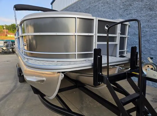 Slide: The Image of 2026 South Bay 224FCR LE pontoon boat on trailer, parked near a blue wall. - 3