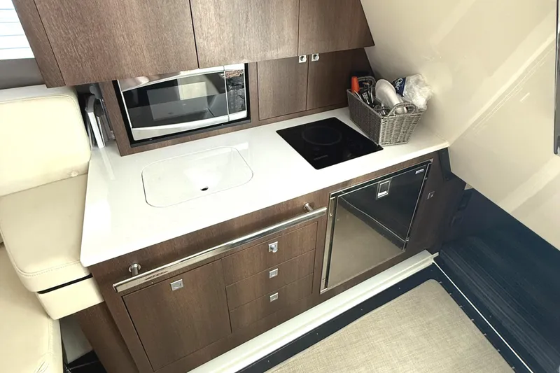 Slide: The Image of Compact kitchen area in 2016 Monterey 360 Sport Coupe with modern appliances and sleek cabinetry. - 18