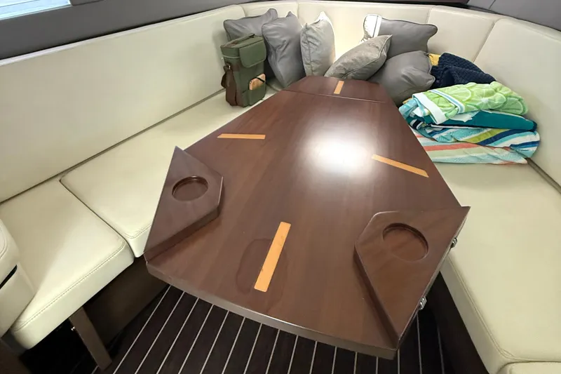 Slide: The Image of Interior of 2016 Monterey 360 Sport Coupe with wooden table and cushioned seating. - 21