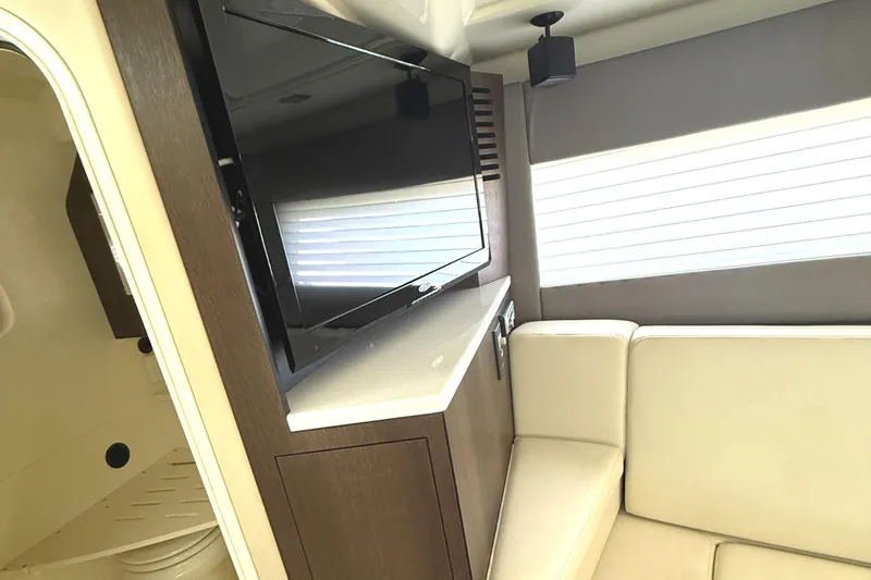 Slide: The Image of Interior of 2016 Monterey 360 Sport Coupe with TV and beige seating. - 24