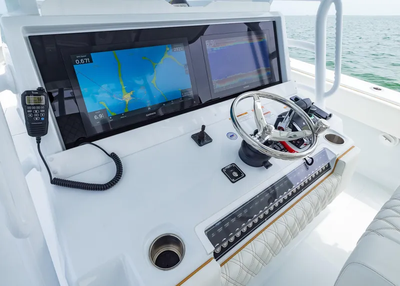 Slide: The Image of Control panel of 2025 Invincible 43 Open Fisherman with navigation screens and steering wheel. - 14