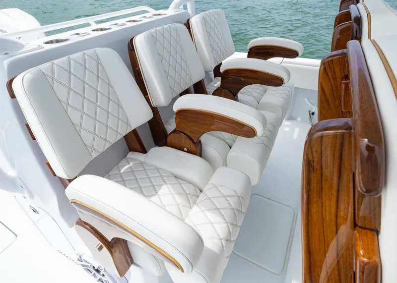 Slide: The Image of Luxurious seating on 2025 Invincible 43 Open Fisherman boat with white cushions and wooden accents. - 18