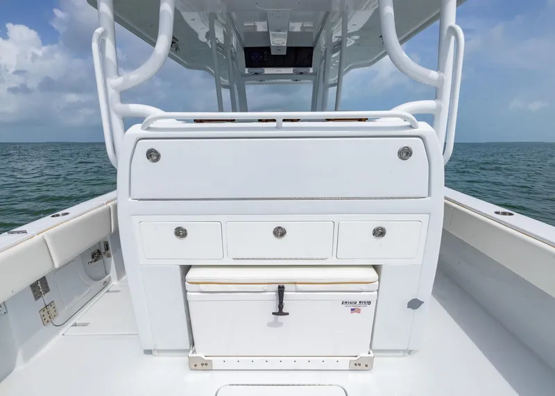 Slide: The Image of 2025 Invincible 43 Open Fisherman boat interior with storage and cooler on open water. - 23