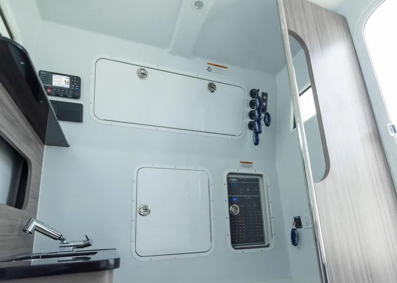 Slide: The Image of 2025 Invincible 43 Open Fisherman interior with control panel and storage compartments. - 32