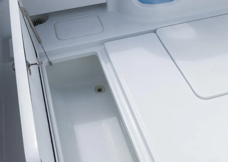 Slide: The Image of 2025 Invincible 43 Open Fisherman boat storage compartment, white interior, open lid. - 38