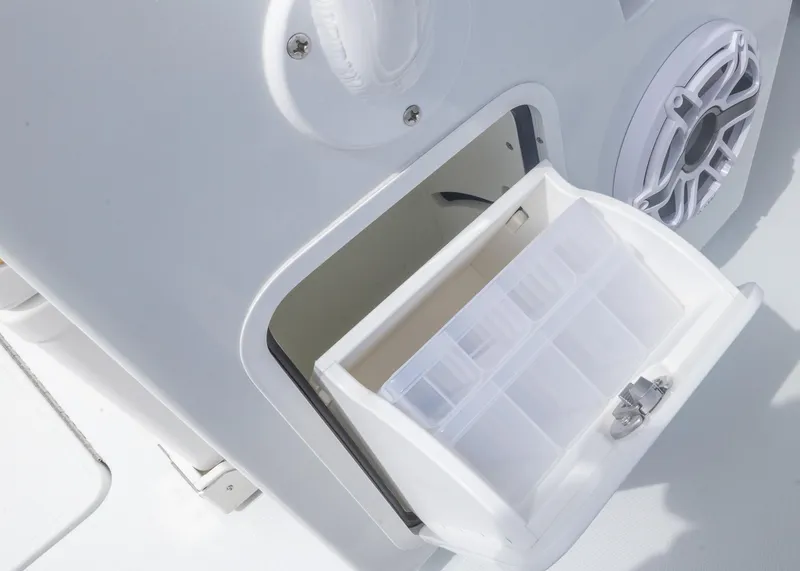 Slide: The Image of Storage compartment on 2025 Invincible 43 Open Fisherman boat, featuring a tackle box and speaker. - 41