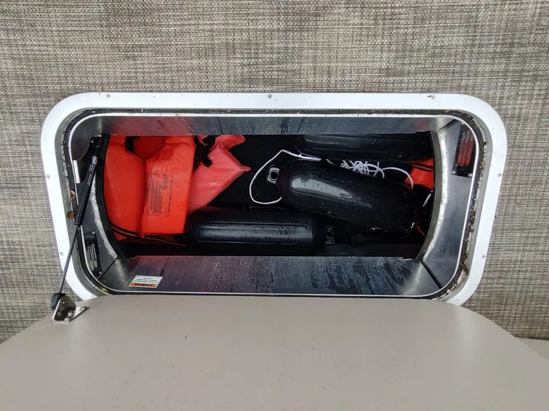 Slide: The Image of Storage compartment in a 2020 Barletta L23QC boat with life jackets and fenders. - 10