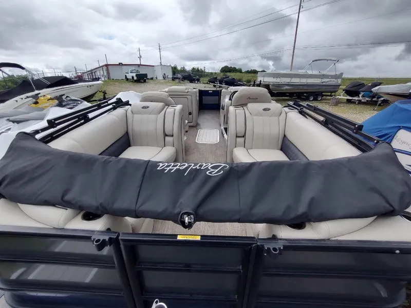 Slide: The Image of 2020 Barletta L23QC pontoon boat with beige seating, parked outdoors under cloudy skies. - 4