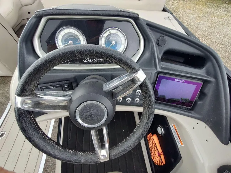 Slide: The Image of Steering wheel and dashboard of 2020 Barletta L23QC boat with gauges and Simrad display. - 7