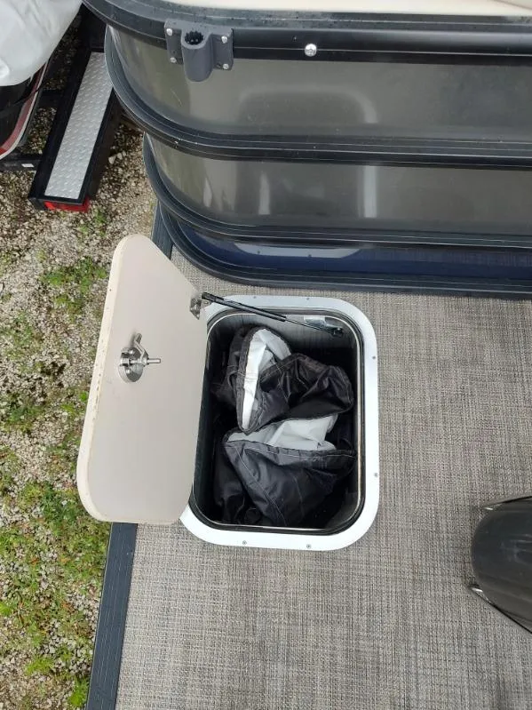 Slide: The Image of Open storage compartment on 2020 Barletta L23QC boat with life jackets inside. - 8
