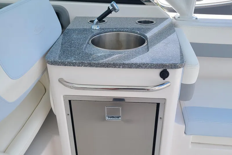 Slide: The Image of 2024 Robalo R317 Dual Console boat kitchenette with sink and storage. - 12