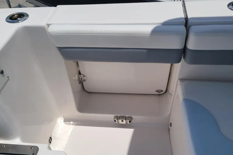 Slide: The Image of 2024 Robalo R317 Dual Console boat seating area with storage compartment. - 13