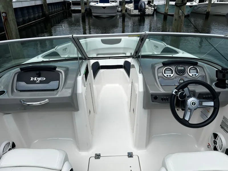 Slide: The Image of 2018 Chaparral 21 H2O Sport OB boat interior with steering wheel and dashboard at marina. - 14