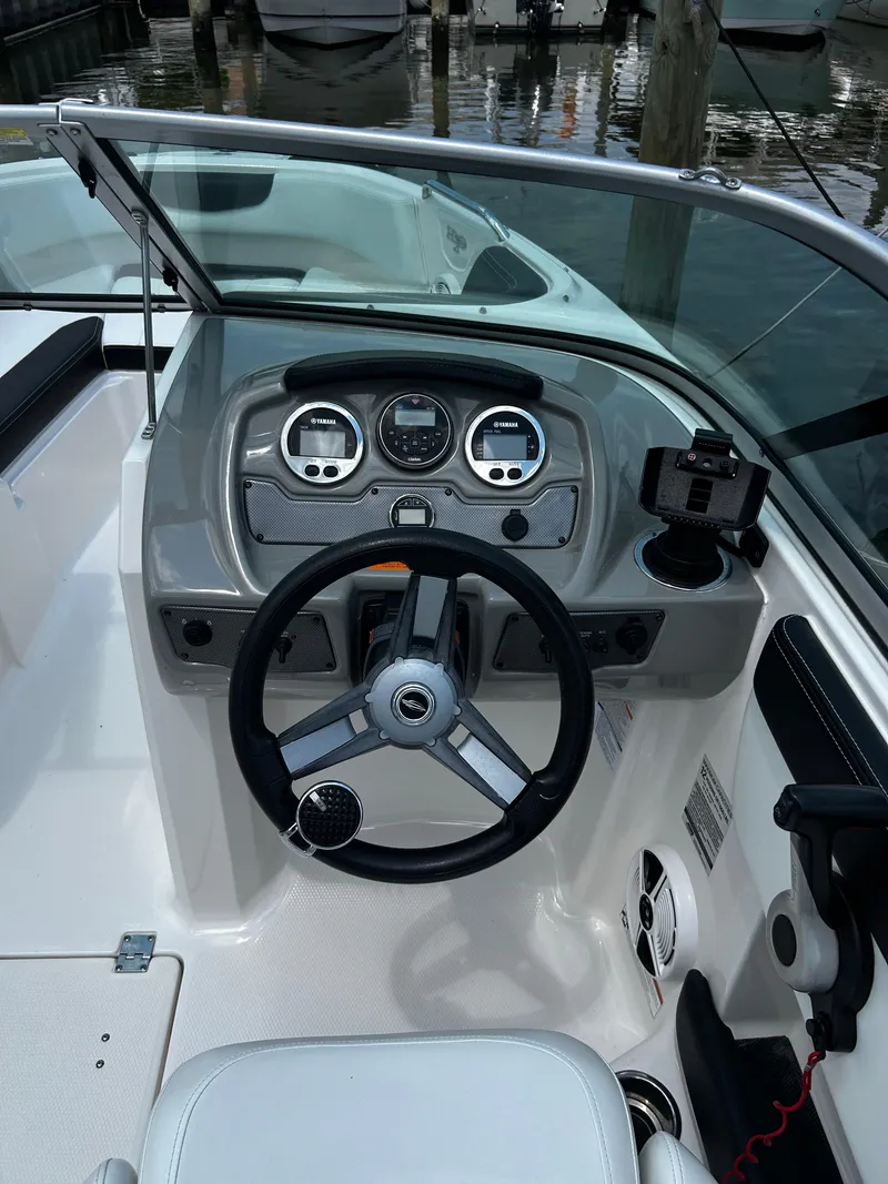 Slide: The Image of 2018 Chaparral 21 H2O Sport OB boat dashboard with steering wheel and gauges. - 15