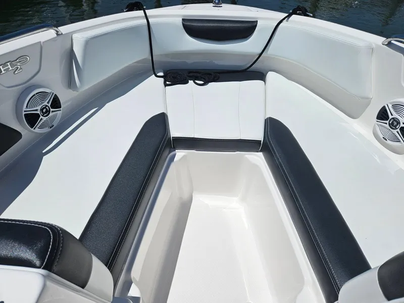 Slide: The Image of 2018 Chaparral 21 H2O Sport OB boat interior with cushioned seating and speakers. - 19