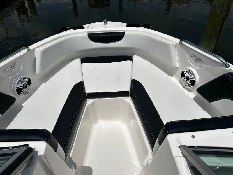 Slide: The Image of 2018 Chaparral 21 H2O Sport OB boat interior with cushioned seating and speakers. - 20