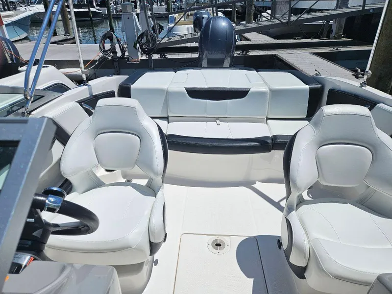 Slide: The Image of 2018 Chaparral 21 H2O Sport OB boat interior with white seating at dock. - 21