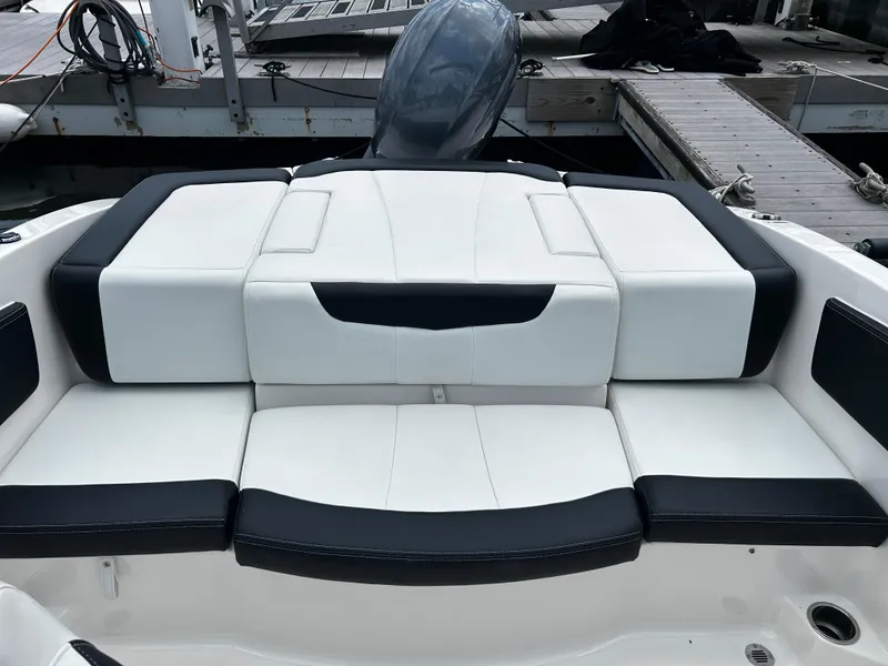 Slide: The Image of 2018 Chaparral 21 H2O Sport OB boat with sleek white and black seating at dock. - 24