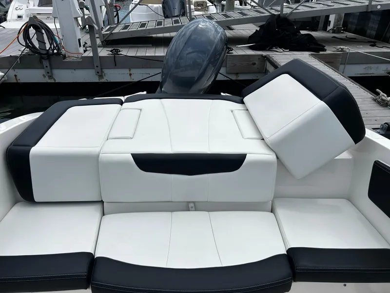 Slide: The Image of 2018 Chaparral 21 H2O Sport OB boat with white and black seating at dock. - 25
