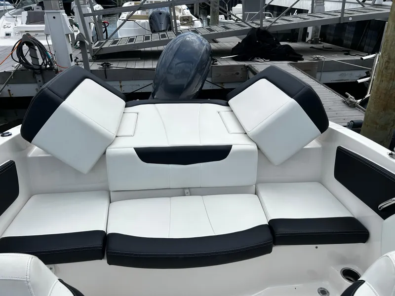 Slide: The Image of 2018 Chaparral 21 H2O Sport OB boat with white and black seating at a dock. - 26
