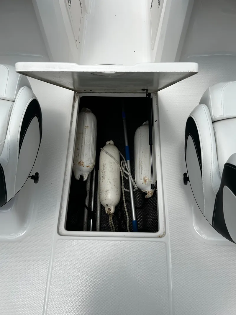 Slide: The Image of 2018 Chaparral 21 H2O Sport OB boat storage compartment with fenders and equipment. - 27