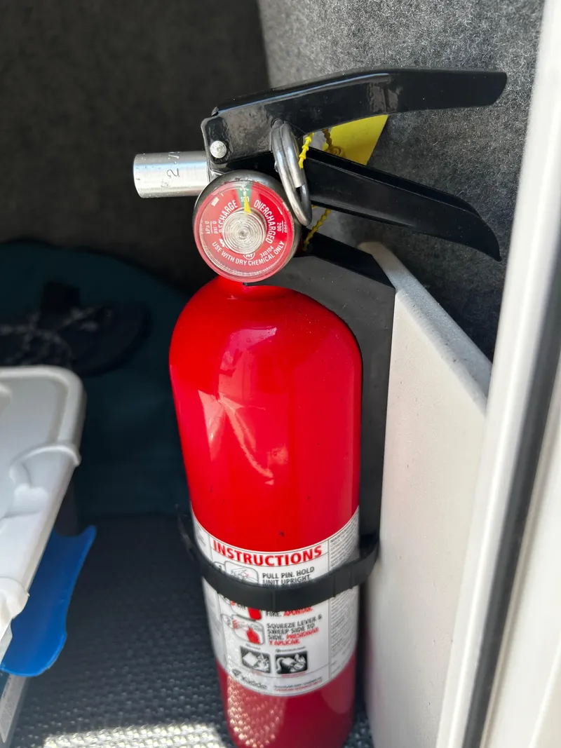Slide: The Image of Red fire extinguisher mounted inside a 2018 Chaparral 21 H2O Sport OB boat. - 35