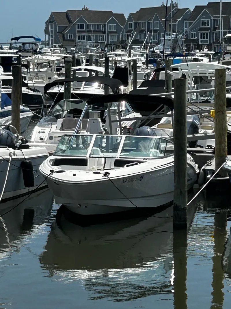 Slide: The Image of 2018 Chaparral 21 H2O Sport OB docked in a marina with other boats. - 7