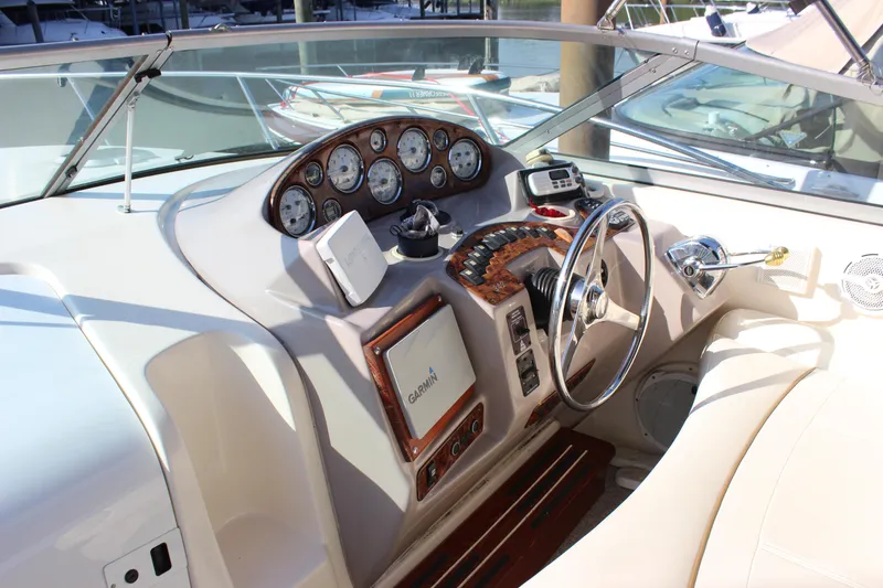 Slide: The Image of 2004 Rinker 342 Express Cruiser helm with gauges, steering wheel, and Garmin navigation system. - 13