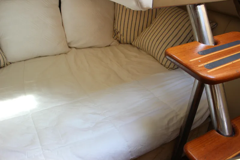 Slide: The Image of Interior cabin of 2004 Rinker 342 Express Cruiser with cozy bedding and wooden steps. - 34